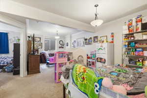 Carpeted bedroom with freestanding refrigerator and ornamental molding