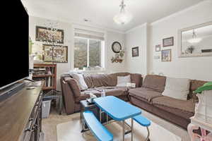 Living room featuring light carpet and ornamental molding