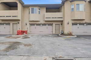View of front of house featuring stucco siding, an attached garage, and asphalt driveway