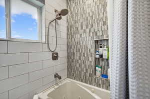 Full bath with a combined bath / shower with jetted tub