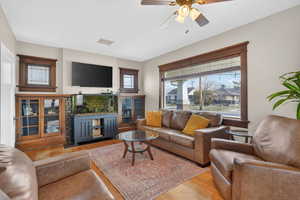 Living area featuring wood finished floors, healthy amount of natural light, and ceiling fan