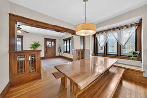 Dining space with light wood-style floors and a ceiling fan