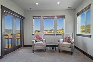 Sitting room with carpet floors, a water and mountain view, and recessed lighting