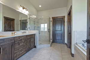 Full bathroom with a stall shower, double vanity, light tile patterned floors, a bath, and recessed lighting