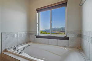 Bathroom featuring healthy amount of natural light, a bath, and a mountain view