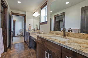Full bath featuring two vanities, recessed lighting, and dark tile patterned flooring