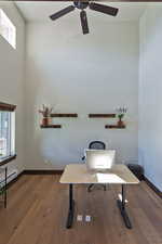 Office with dark wood finished floors, healthy amount of natural light, and a ceiling fan