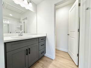 Full bathroom featuring vanity, light wood-type flooring, and an enclosed shower