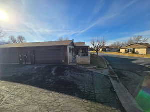 View of side of property with a residential view, driveway, an attached garage, and a shingled roof