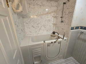 Bathroom featuring a bathtub and tile walls