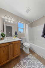 Bathroom with shower / bathtub combination with curtain, vanity, and dark tile patterned flooring