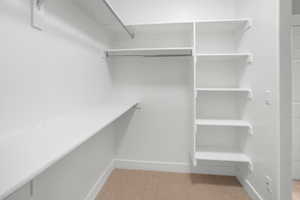 Walk in closet featuring light carpet