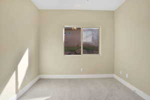 Spare room featuring carpet floors and baseboards