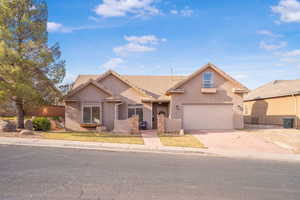 Traditional home featuring a tile roof, stucco siding, and concrete driveway