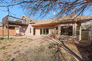 Rear view of property featuring a patio, stucco siding, and a tiled roof