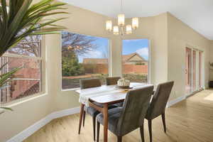 Dining room with light wood-type flooring and hanging lights
