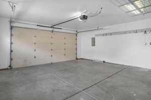 Garage with electric panel and a garage door opener