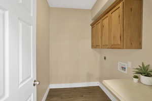 Laundry area with dark wood-style flooring, washer hookup, cabinet space, and electric dryer hookup
