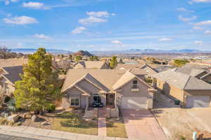 View of front facade featuring a residential view, driveway, stucco siding, a garage, and a mountain view