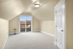 Additional living space with light carpet and baseboards