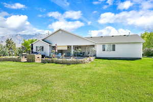 Rear view of property featuring a patio and a yard