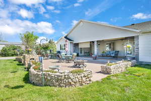 Back of property featuring a patio, a yard, and a ceiling fan