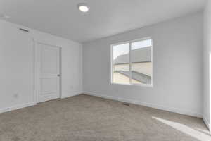 Unfurnished room featuring baseboards and light carpet