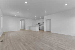 Unfurnished living room with light wood-style flooring and recessed lighting