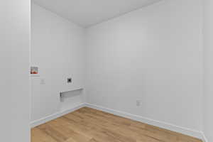 Laundry room featuring hookup for a washing machine, light wood-style flooring, and electric dryer hookup