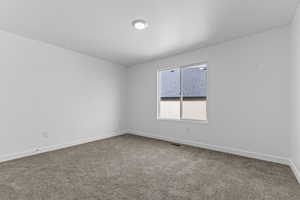 Unfurnished room featuring light carpet and a textured ceiling