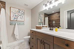 Bathroom featuring vanity and shower / bath combination with curtain