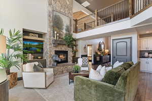Living area with a high ceiling and a stone fireplace