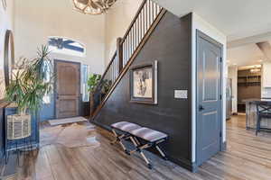 Entrance foyer with light wood-style floors, a high ceiling, and a chandelier