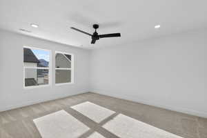 Empty room featuring light carpet, ceiling fan, and recessed lighting