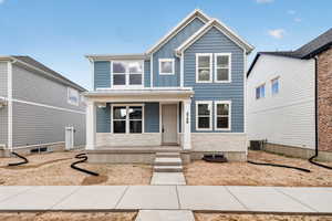 View of front of property with a porch, board and batten siding, and a standing seam roof