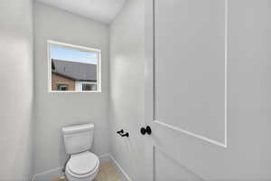 Bathroom with toilet and light tile patterned floors