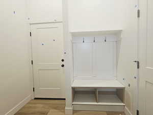 Mudroom with light wood finished floors and baseboards