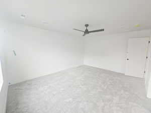 Spare room with light carpet and a ceiling fan
