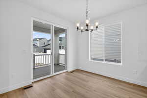 Unfurnished dining area featuring suspended lighting and light wood finished floors