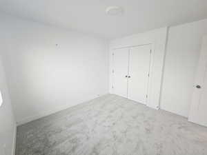 Unfurnished bedroom featuring carpet flooring and a closet