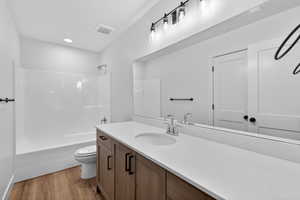 Bathroom with vanity, light wood-style floors, and shower / tub combination
