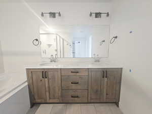 Full bathroom featuring double vanity, a shower stall, and a bath