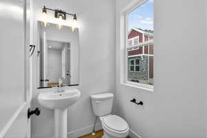 Half bathroom featuring toilet and baseboards