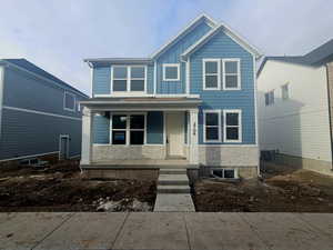 View of front facade featuring stone siding, a porch, and board and batten siding