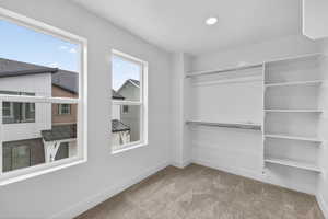 Walk in closet featuring light carpet