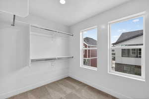 Walk in closet with light carpet