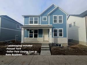 View of front facade featuring covered porch, stone siding, and board and batten siding