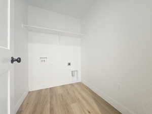 Laundry area with wood finished floors, hookup for an electric dryer, and washer hookup