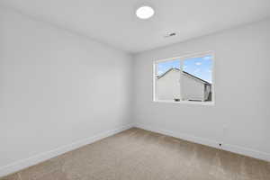 Empty room featuring baseboards and light carpet