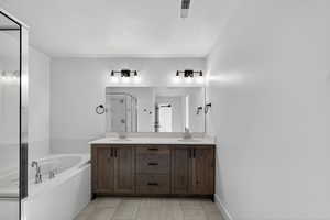 Full bathroom featuring double vanity, a shower stall, a bath, and a textured ceiling